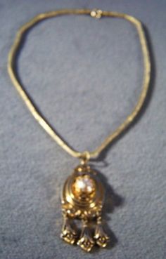 I am offering you this fabulous Victorian-style vintage yellow gold tone wide unique design lavaliere style necklace. It is a bold wonderful design that has such movement and flexibility to it , and such a gorgeous ornate design. Just look at the endless amounts of scrolled etched designs here, accented with jet black enameling. It is also accented with a faux pearl. Creating this dangle lavaliere section of this necklace, creating a wonderful shape giving this amazing necklace such added intere Gold Elegant Collectible Necklace, Elegant Gold-tone Chain Necklace With Locket, Formal Metal Necklace With Locket, Formal Metal Locket Necklace, Gold Victorian Necklace For Evening, Gold Filigree Necklaces For Evening, Victorian Gold Necklace For Evening, Gold Filigree Necklace For Collectors, Ornate Gold Collectible Necklace