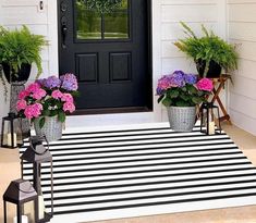 front porch decorated with potted flowers and lanterns for the entrance to a house or office