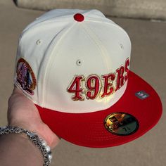 a person holding up a white and red hat with the number forty four on it