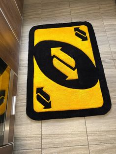 a yellow and black area rug with an arrow on the floor in front of it