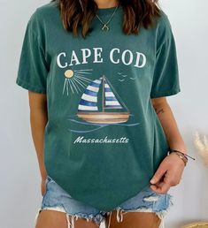 The Cape Cod Sailboat Tshirt is a stylish and comfortable garment perfect for sailing enthusiasts and Cape Cod lovers. Featuring a detailed sailboat graphic, this shirt captures the essence of Cape Cod's maritime charm. Made from soft, high-quality fabric, it offers a relaxed fit ideal for casual outings or coastal adventures. This tee makes an excellent gift for those who appreciate nautical themes and the scenic beauty of Cape Cod Massachusetts. The Comfort Colors C1717 100% Ring Spun Cotton T Cod Clothes, Sailboat Graphic, Perfect Live, Cape Cod Massachusetts, Beach Tee, Scenic Beauty, Limassol, Life Design, Look Plus