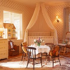 a baby's room with teddy bears sitting at a table and chairs in front of the crib