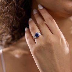 a close up of a person wearing a ring with a blue gemstone on it