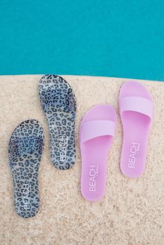 three pairs of slippers sitting next to a swimming pool