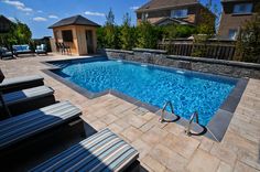 an empty swimming pool with lounge chairs around it