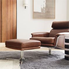 a brown leather chair and ottoman in a living room