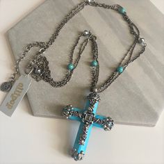 "Vintage 1990s Gothic style magnesite? turquoise cross pendant necklace. Stunning exquisite cross has  silver tone filigree detailing of vines, leaves, flowers and scrolls with glass crystal accents. I believe  the cross is made of magnesite, a mineral that has turquoise color. The cross comes on a 3 strand silver tone chain accented with round turquoise beads and antiqued silver tone beads. It is NOS (new old stock) with the original Olipop paper tags. Olipop is a division of Sweet Romance and Blue Bohemian Necklace With Cross Pendant, Bohemian Blue Cross Pendant Necklace, Silver Turquoise Cross Necklace For Gift, Boho Charm Bracelet, Turquoise Cross Necklace, Vines Leaves, Turquoise Cross Pendant, Turquoise Cross, Sweet Romance