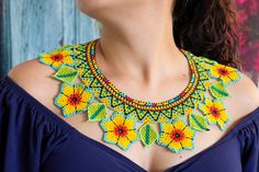 a woman wearing a colorful necklace with flowers on the front and back of her neck