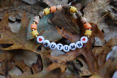 This stylish autumn bracelet is perfect for autumn, we have all the autumn colors here from, yellow, to orange, and different shades of brown! It is made with clay beads, letter beads, and metal pieces are in between each color, the metal pieces will tarnish in water. The ends of the bracelet are sealed with nail polish, so the bracelet will not fall apart. If you want the bracelet to say fall please contact the owner. Fall Bead, Homemade Bracelets, Autumn Bracelet, Clay Bead Bracelet, Autumn Necklace, Halloween Bracelet, Clay Bracelet, Iron Beads, Diy Bracelets Patterns