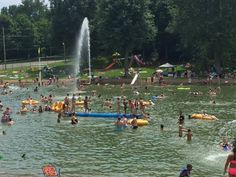 many people are swimming in the water and having fun at the park while others watch