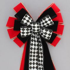 a black, white and red bow on a gray background with gold trimmings