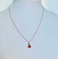 "A beautiful 14K solid yellow gold Red Cherry puffy charm / pendant with hand painted and baked enamel. It has a soldered ring to attach to a bracelet or a necklace. The small pendant measures 10mm (0.39\") tall with bail and without the soldered ring and 7.3mm (0.29\") wide. It can be used as a necklace pendant or a bracelet charm and would make a perfect gift. The pendant can be paired with a shiny 14K Yellow Gold 1.2mm cable link chain in either 16\" or 18\" length or with a 16\" 14K gold-pla Handmade Yellow Gold Enamel Necklaces, Handmade Yellow Gold Enamel Necklace, Dainty Tiny Red Jewelry, Yellow Gold Enamel Round Pendant Charm Necklace, Yellow Gold Enamel Charms For Gift, Round Enamel Jewelry With Vintage Charm, Vintage Charm Round Enamel Jewelry, Red Enamel Jewelry With Charms, Red Enamel Charm Necklaces For Gifts