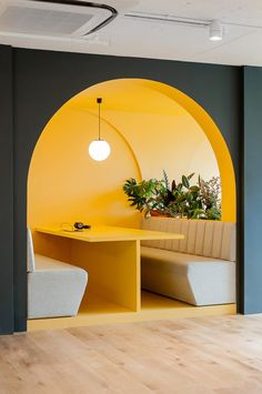 a room with yellow walls and white chairs in front of a table that has a potted plant on it