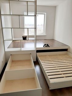 a bed with drawers underneath it and a window in the back ground, next to another bed