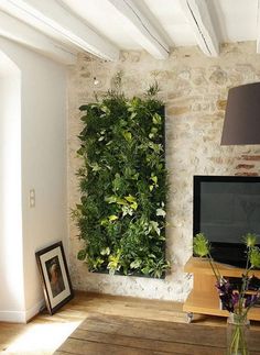 a living room with a tv and plants on the wall