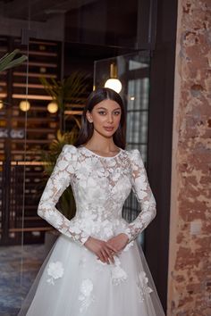 a woman in a white wedding dress posing for the camera