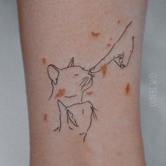 a small tattoo on the leg of a woman's arm with a cat and mouse