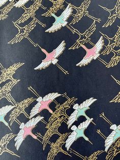 a black background with pink and blue birds on it's side, in gold foil