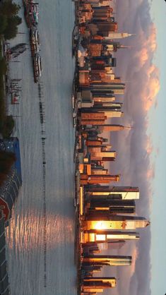 an image of the beach at sunset with boats in the water and buildings on the shore