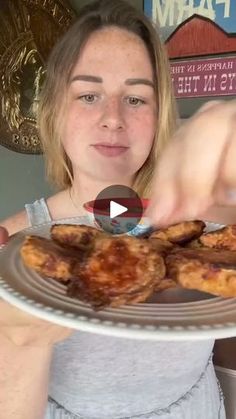 a woman holding a plate with some food on it