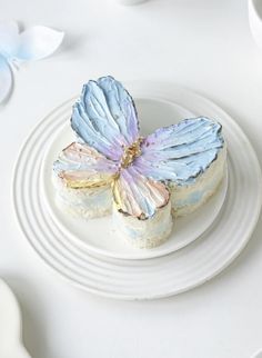 a white plate topped with two pieces of cake covered in frosting next to flowers