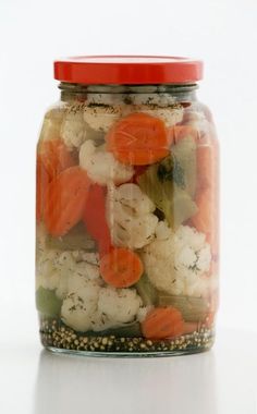 a jar filled with carrots, cauliflower and other vegtables