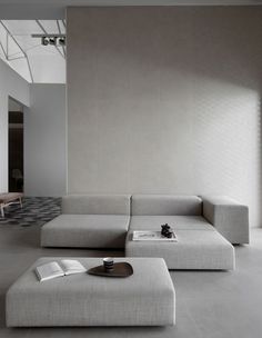 a large white couch sitting in a living room next to a table with a book on it