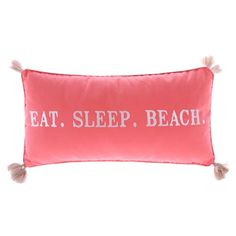 a pink pillow that says eat sleep beach with tassels on the front and back