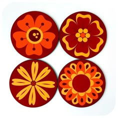 four red and yellow flower coasters on a white surface