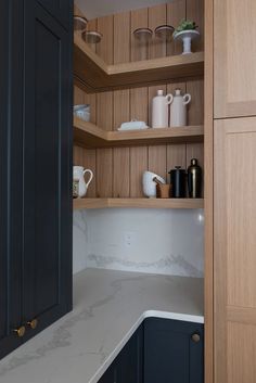 a kitchen with black cabinets and white counter tops