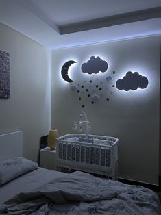 a baby's room with a crib and moon lights on the wall above it