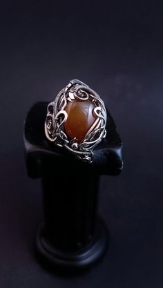 A large ring with ginger chalcedony is woven using the wire wrap technique. The ring is adjustable in size and can be adjusted to suit yours. To do this, select the size that suits you best from the menu. If you would like to purchase a set, I can offer you a bracelet https://www.etsy.com/listing/1664295369/adjustable-wire-wrapped-chalcedony?ref=listings_manager_grid ATTENTION: Please note that In reality colors of jewelry may look slightly different than colors in photos on your screen. It depends on your monitor calibration and its color rendering. HOW TO CARE: Over time, the metal may darken slightly. It depends on the degree of contamination of the surface of the jewelry. It is very easy to clean metal with cloths for jewelry. Or rub thoroughly with a toothbrush with toothpaste. After Handmade Adjustable Moonstone Ring, Handmade Adjustable Unique Moonstone Ring, Unique Handmade Adjustable Moonstone Ring, Bohemian Wire Wrapped Chalcedony Jewelry, Bohemian Chalcedony Wire Wrapped Jewelry, Adjustable Amber Wire Wrapped Jewelry, Handmade Agate Rings As Gift, Handmade Agate Rings For Gift, Handmade Adjustable Agate Ring