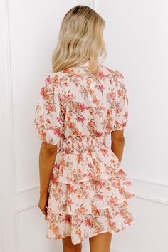 - This mini dress is perfect for a romantic lunch date with your sweetheart! - Unlined lightweight material with a pink, yellow, and orange hued floral design - A v-cut neckline that goes into a button-down bodice - Short sleeves with elastic cuffs - A wide smocked waistline - A tiered skirt - A figure flattering silhouette that ends in a straight mini dress length hemline Measurements S : Bust 36", Hip 36", Length 31.5", Sleeve Length 12", Waist 24-36". M : Bust 38", Hip 38", Length 31.5", Slee Pink Floral Print V-neck Mini Dress, Apricot V-neck Mini Dress For Summer, Summer V-neck Mini Dress In Apricot, Summer V-neck Apricot Mini Dress, Peach V-neck Dress For Brunch, Peach Floral Print Mini Dress For Vacation, Peach Floral Print Mini Dress For Summer, Peach Floral Print Mini Dress For Garden Party, Peach Floral Print Mini Dress For Spring