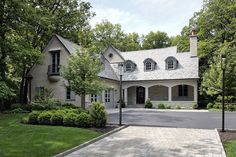 a large white house surrounded by lush green trees