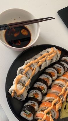 sushi and chopsticks on a black plate