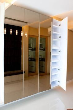 an empty room with mirrored doors and shelves