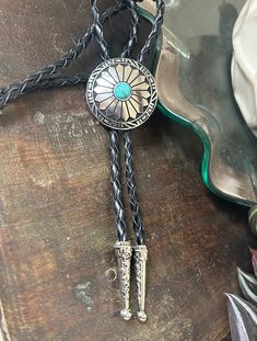 "This awesome bolo tie has a southwestern design and turquoise centerpiece. Our bolos pair nicely with many of our belt buckles! They make wonderful gifts. The western bolo tie rope length is 100cm(39\")" Bohemian Hand Tooled Jewelry For Rodeo, Traditional Concho Jewelry For Western-themed Events, Concho Jewelry For Rodeo, Southwestern Style Adjustable Bolo Ties, Western Style Concho Jewelry For Gift, Western Style Concho Jewelry As Gift, Adjustable Concho Jewelry For Rodeo, Artisan Hand-tooled Jewelry For Rodeo, Southwestern Lariat Bolo Tie For Rodeo