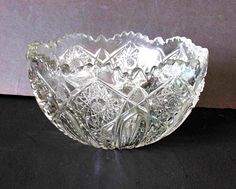 a clear glass bowl sitting on top of a black tablecloth covered floor next to a wall