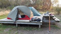 a tent is set up on a wooden platform