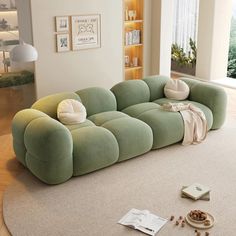 a large green couch sitting on top of a white rug