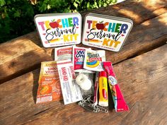 two tins filled with school supplies sitting on top of a wooden bench next to trees