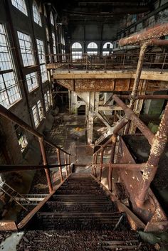 an abandoned building with lots of windows and rusted metal stairs leading up to the second floor