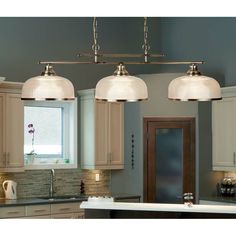 three lights hanging over a kitchen island in a home