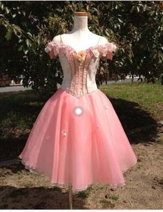 a pink dress on display in front of some trees