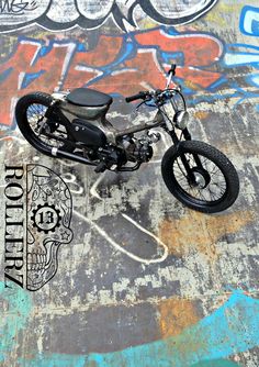 a black motorcycle parked in front of a wall with graffiti on it's walls