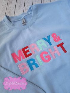 This Merry & Bright Sweatshirt will be the envy of all your festive friends. It's colorful, trendsetting and perfect for your Christmas wardrobe. Available in pink, grey or blue, this stylish sweatshirt is sure to bring some seasonal cheer! All of my items are made to order, if you have any questions please don't hesitate to ask! Pink Winter Sweatshirt With Embroidered Graphics, Winter Pink Sweatshirt With Embroidered Graphics, Fun Cotton Sweatshirt For Winter, Pink Cotton Holiday Sweatshirt, Blue Winter Sweater With Embroidered Text, Embroidered Blue Winter Tops, Winter Blue Sweater With Embroidered Text, Winter Blue Tops With Embroidered Graphics, Blue Crew Neck Top For Holiday