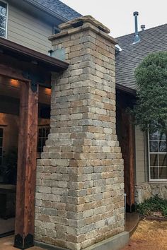 a tall brick chimney in front of a house