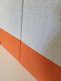 an orange and grey headboard on a white bed