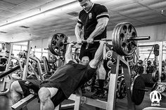 a man is doing a bench press in the gym