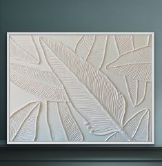 an abstract painting with white leaves on the wall